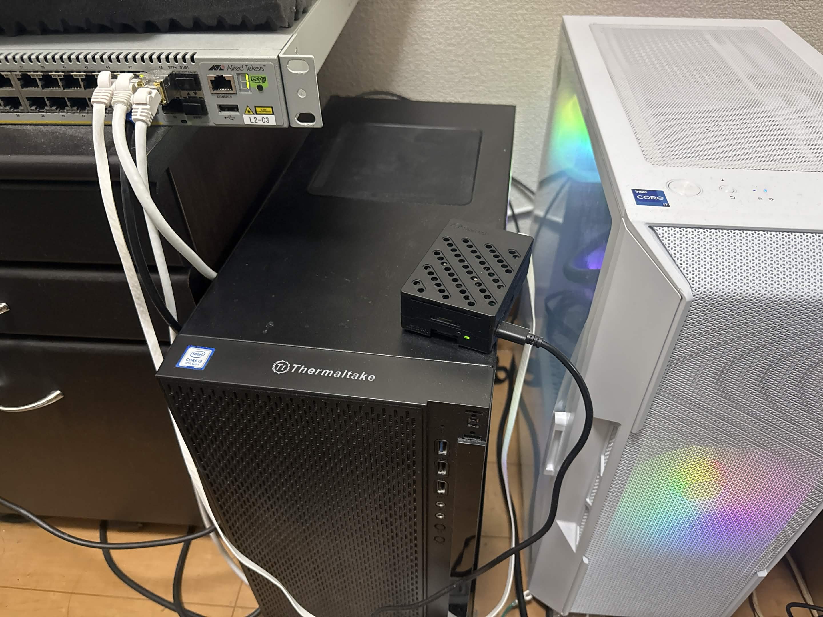 自宅サーバーの実機。左上に AT-x510-52GTX スイッチ、中央下にサブ機、その上に Raspberry Pi 5、右にメイン機